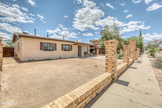 view of front of home with fence and a patio area
