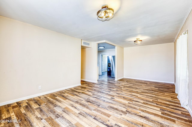 spare room with wood finished floors and baseboards