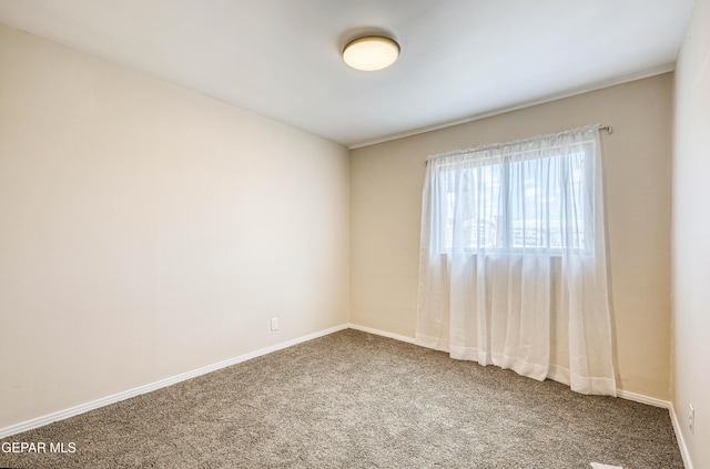 carpeted empty room with baseboards