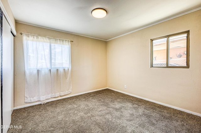 carpeted empty room featuring healthy amount of natural light, ornamental molding, and baseboards