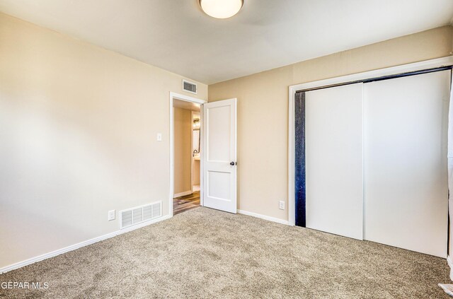 unfurnished bedroom with carpet flooring, a closet, and baseboards