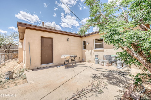 back of house with stucco siding, a patio area, and fence