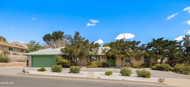 single story home with an attached garage, brick siding, and concrete driveway