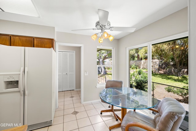 dining area featuring light tile patterned floors, ceiling fan, and baseboards