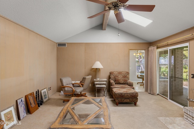 living area with carpet floors, a ceiling fan, and a skylight