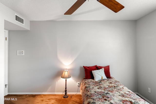 bedroom featuring carpet flooring, baseboards, a textured ceiling, and a ceiling fan
