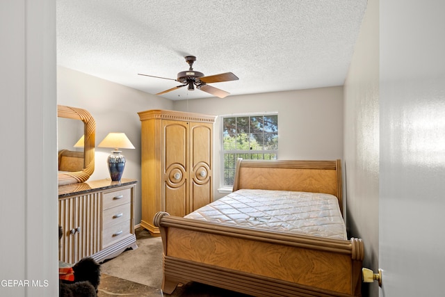 carpeted bedroom featuring a textured ceiling and ceiling fan