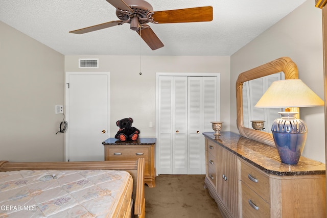 bedroom with light colored carpet, a closet, ceiling fan, and a textured ceiling
