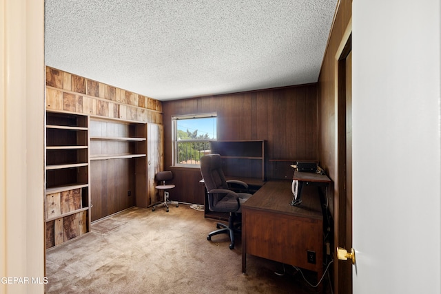 carpeted home office with wood walls and a textured ceiling