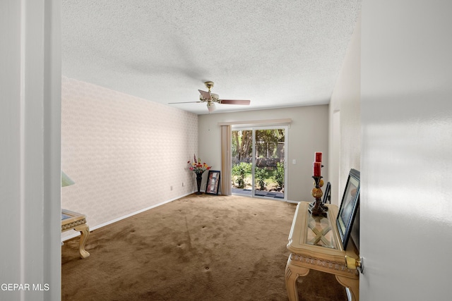 unfurnished room with wallpapered walls, carpet flooring, a textured ceiling, baseboards, and ceiling fan