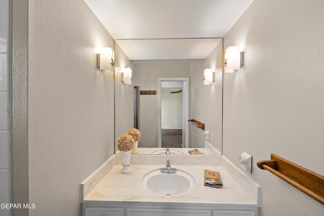bathroom with vanity and a textured wall