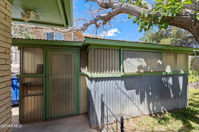 view of property exterior with metal roof and an outbuilding