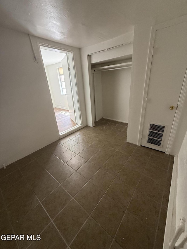 716 N Glenwood St, El Paso, TX 79905 - unfurnished bedroom featuring dark tile patterned floors and a closet