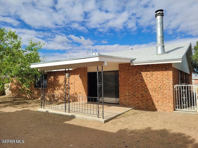 7716 Iroquois Dr, El Paso, TX 79912 - rear view of property with brick siding and a patio area