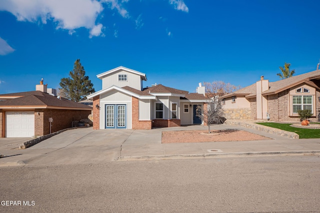 12033 Fred Carter Dr, El Paso, TX 79936 - view of front facade featuring french doors, brick siding, and an attached garage