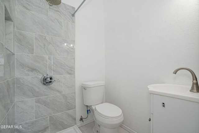 12033 Fred Carter Dr, El Paso, TX 79936 - bathroom featuring tiled shower, toilet, vanity, and baseboards
