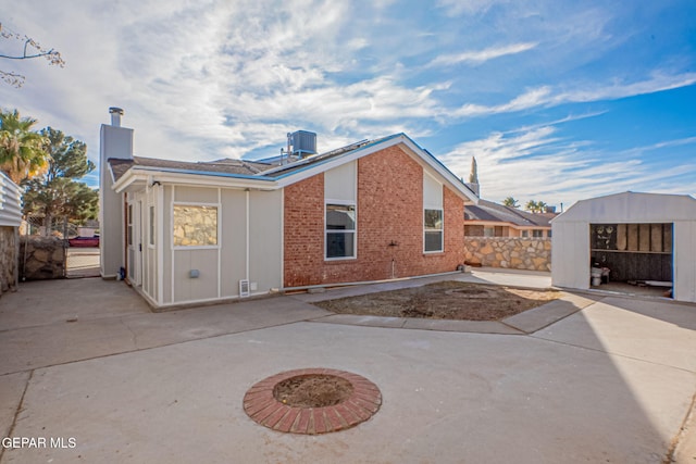 12033 Fred Carter Dr, El Paso, TX 79936 - rear view of property with a patio, a chimney, central AC unit, a shed, and fence