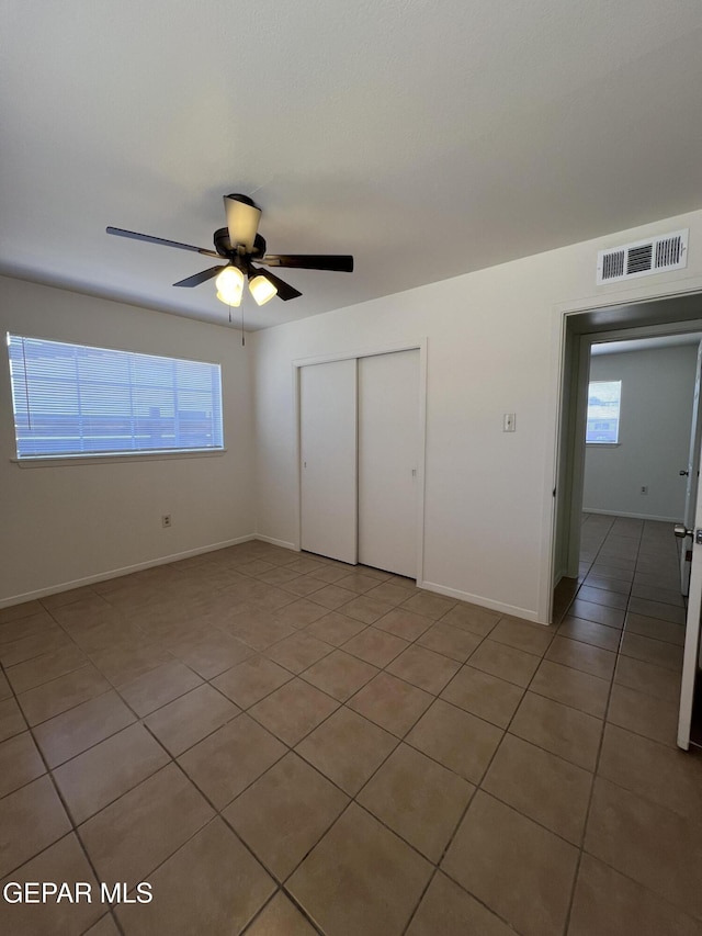 6044 Cabrillo Dr, El Paso, TX 79912 - unfurnished bedroom with a closet, multiple windows, light tile patterned floors, and a ceiling fan