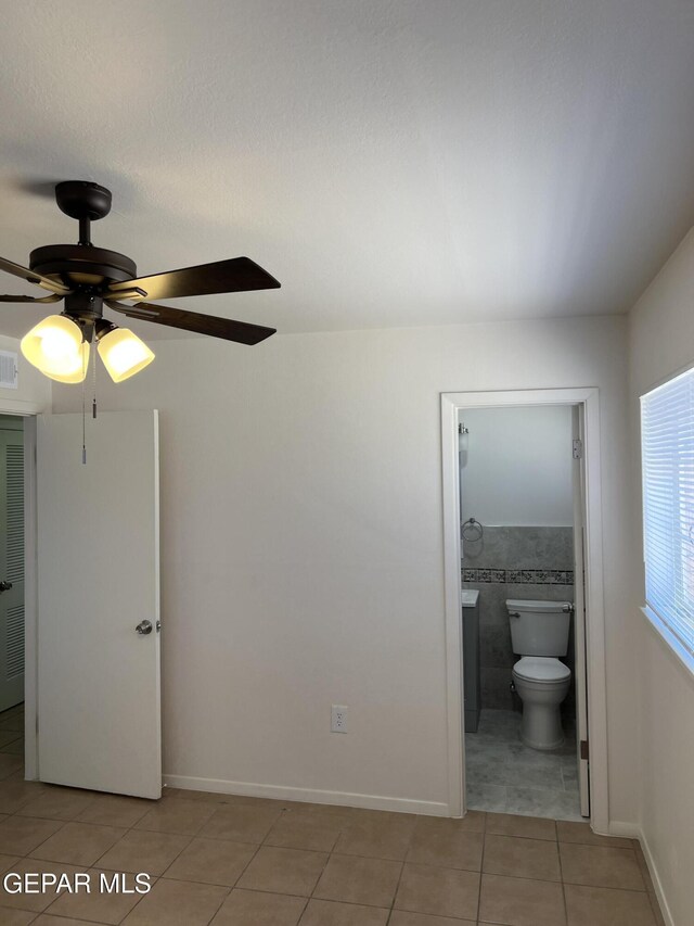6044 Cabrillo Dr, El Paso, TX 79912 - unfurnished bedroom featuring light tile patterned floors, connected bathroom, and a ceiling fan