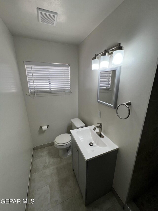 6044 Cabrillo Dr, El Paso, TX 79912 - bathroom with toilet, vanity, tile patterned floors, and baseboards