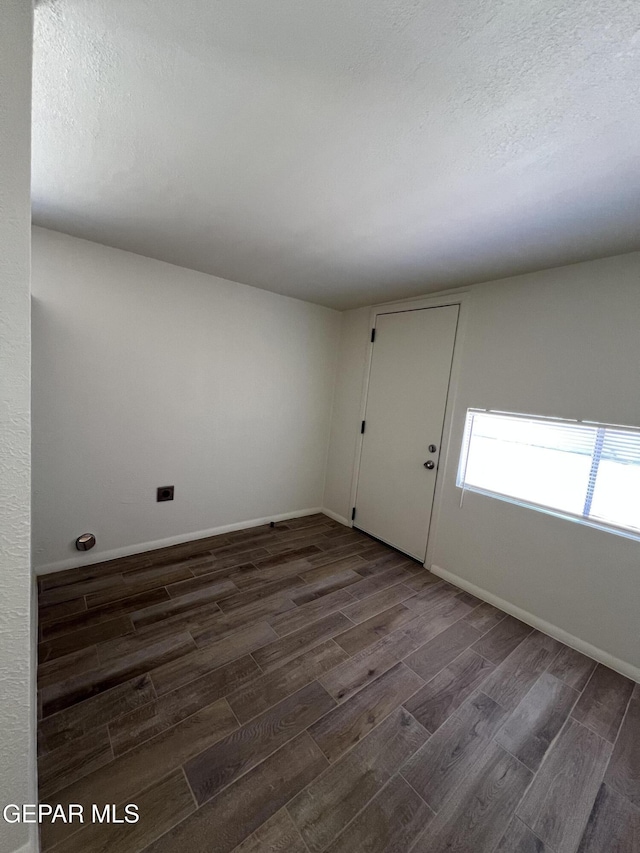 6044 Cabrillo Dr, El Paso, TX 79912 - empty room with dark wood-style flooring, a textured ceiling, and baseboards