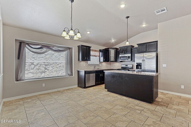 13001 Lost Willow, El Paso, TX 79938 - kitchen with stainless steel appliances, backsplash, dark cabinetry, a chandelier, and vaulted ceiling