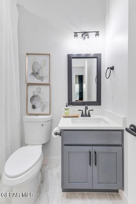 10705 Troy Aikman Dr, El Paso, TX 79924 - bathroom featuring baseboards, toilet, vanity, and marble look tile flooring