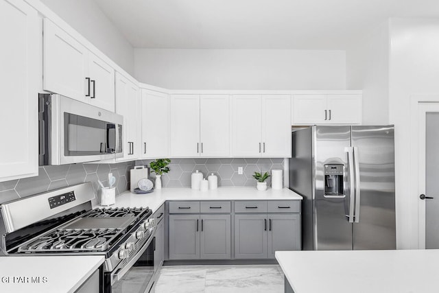 10705 Troy Aikman Dr, El Paso, TX 79924 - kitchen featuring stainless steel appliances, gray cabinetry, light marble finish flooring, and light countertops