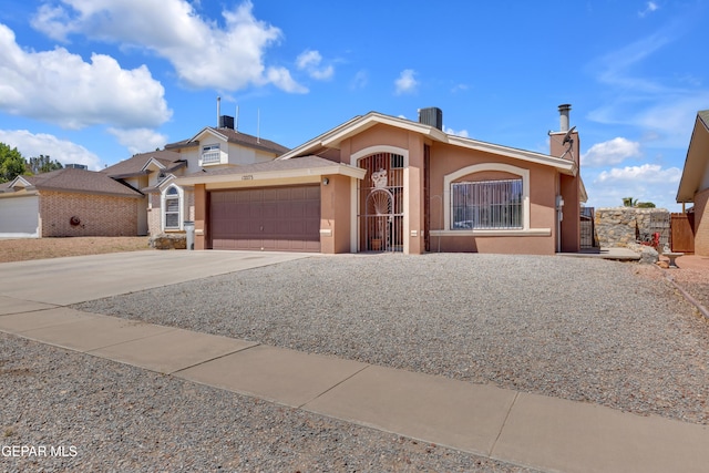12273 El Greco Cir, El Paso, TX 79936 - view of front facade featuring a garage, driveway, stucco siding, fence, and a gate