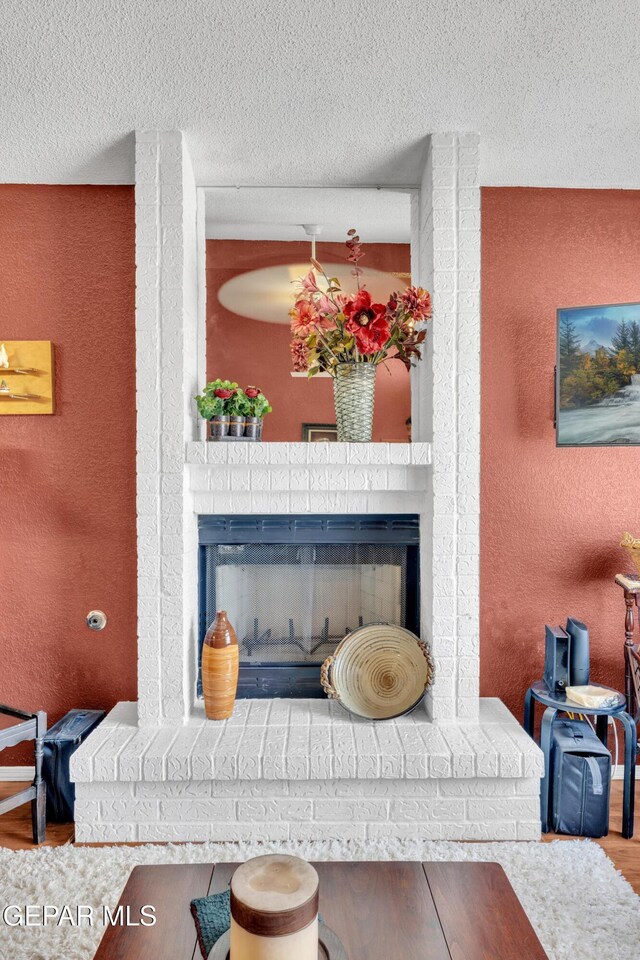 12273 El Greco Cir, El Paso, TX 79936 - detailed view of a fireplace, wood finished floors, a textured wall, and a textured ceiling