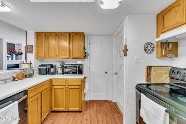 12273 El Greco Cir, El Paso, TX 79936 - kitchen featuring black / electric stove, light wood finished floors, under cabinet range hood, light countertops, and a textured ceiling