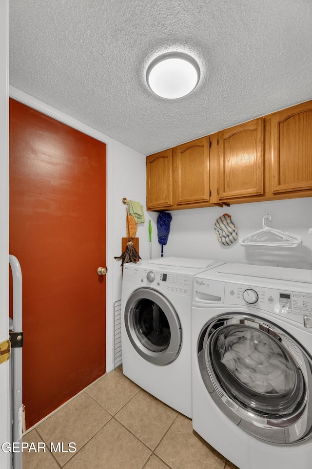 12273 El Greco Cir, El Paso, TX 79936 - laundry room with cabinet space, a textured ceiling, washing machine and dryer, and light tile patterned floors