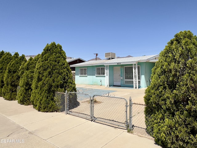 single story home with a gate, fence, central air condition unit, and stucco siding