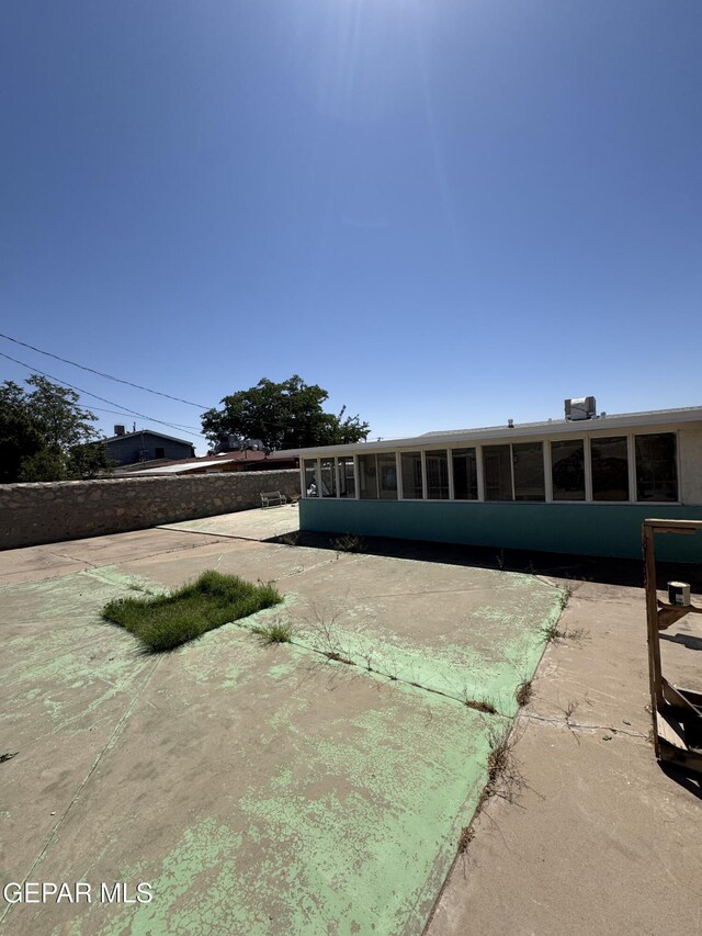 view of front of property featuring a sunroom and a patio