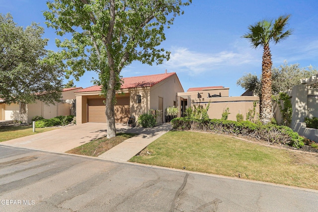 1114 Los Jardines Cir, El Paso, TX 79912 - view of front of home with stucco siding, a garage, driveway, a front yard, and a tiled roof