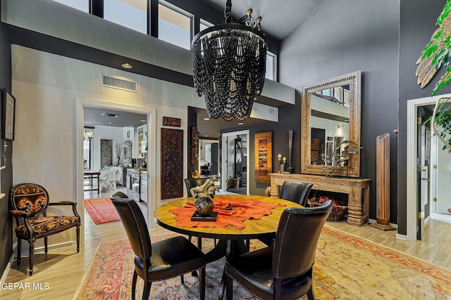 1114 Los Jardines Cir, El Paso, TX 79912 - dining room featuring high vaulted ceiling, a chandelier, light wood finished floors, healthy amount of natural light, and baseboards