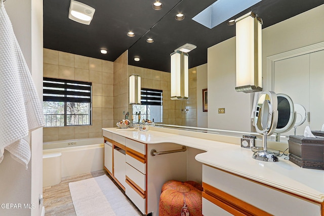 1114 Los Jardines Cir, El Paso, TX 79912 - full bath featuring a skylight, vanity, a garden tub, and recessed lighting