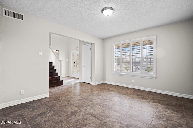 1393 Vista Granada Dr, El Paso, TX 79936 - spare room with stairway, a textured ceiling, and baseboards