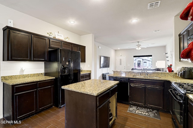 kitchen with black appliances, a sink, wood tiled floors, dark brown cabinets, and recessed lighting