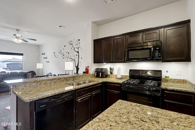 kitchen with black appliances, a sink, open floor plan, ceiling fan, and light stone countertops