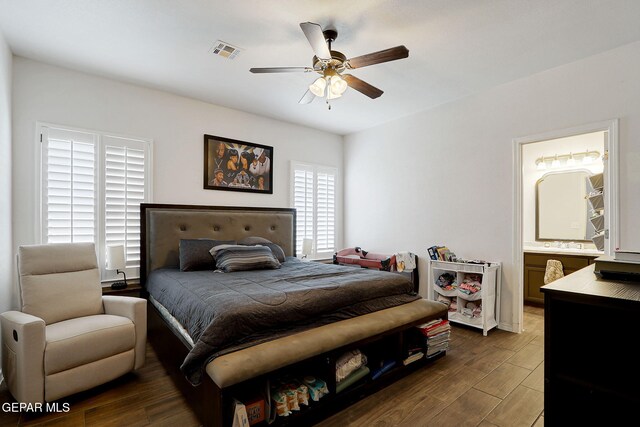 bedroom featuring dark wood-style flooring, ensuite bathroom, and ceiling fan