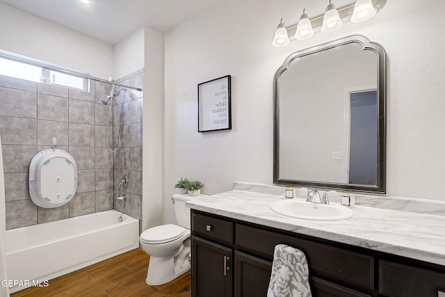 full bath featuring wood finished floors, vanity, toilet, and shower / washtub combination