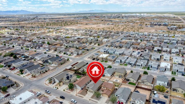 aerial view of property and surrounding area featuring a mountain backdrop and nearby suburban area