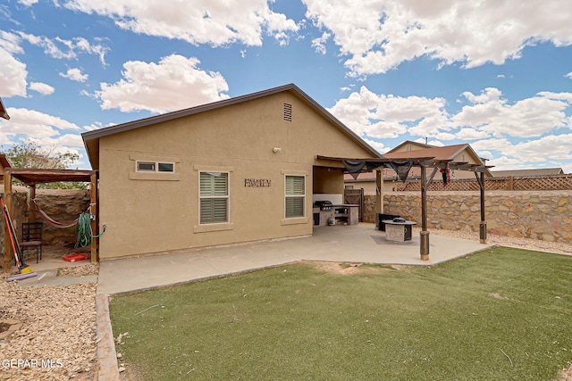 rear view of house with stucco siding, a patio, and a gazebo