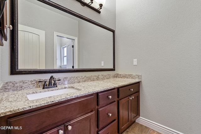737 Colonial Blf, El Paso, TX 79928 - bathroom with vanity, a textured wall, and baseboards