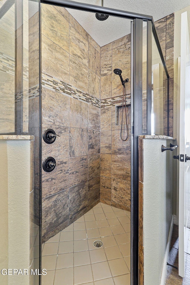 737 Colonial Blf, El Paso, TX 79928 - full bathroom featuring a shower stall, a textured ceiling, and tile patterned flooring