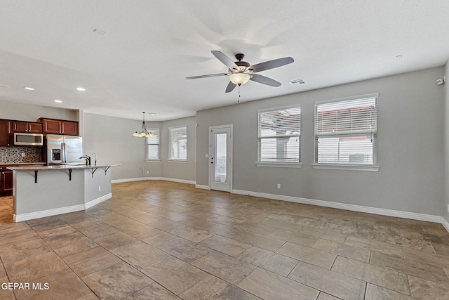 737 Colonial Blf, El Paso, TX 79928 - unfurnished living room featuring a ceiling fan, recessed lighting, baseboards, a chandelier, and a sink
