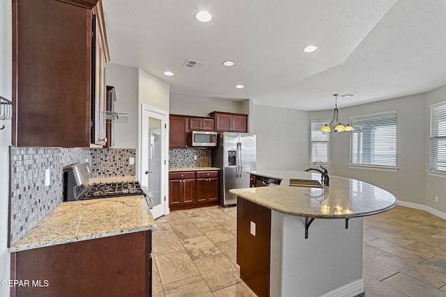 737 Colonial Blf, El Paso, TX 79928 - kitchen featuring stainless steel appliances, a sink, decorative backsplash, a breakfast bar area, and a chandelier