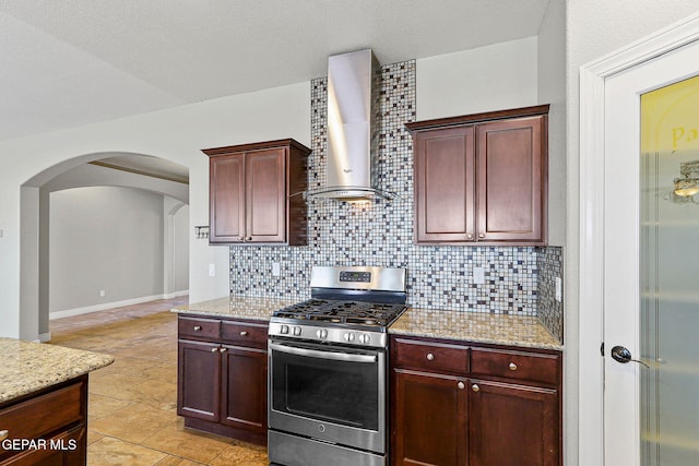 737 Colonial Blf, El Paso, TX 79928 - kitchen with gas stove, wall chimney range hood, decorative backsplash, and arched walkways