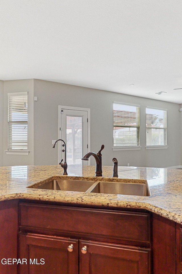 737 Colonial Blf, El Paso, TX 79928 - kitchen with a sink, reddish brown cabinets, and light stone countertops